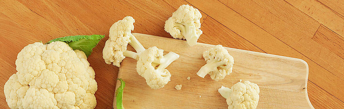 Blumenkohl und Blumemkohlröschen auf einem Holzbrett