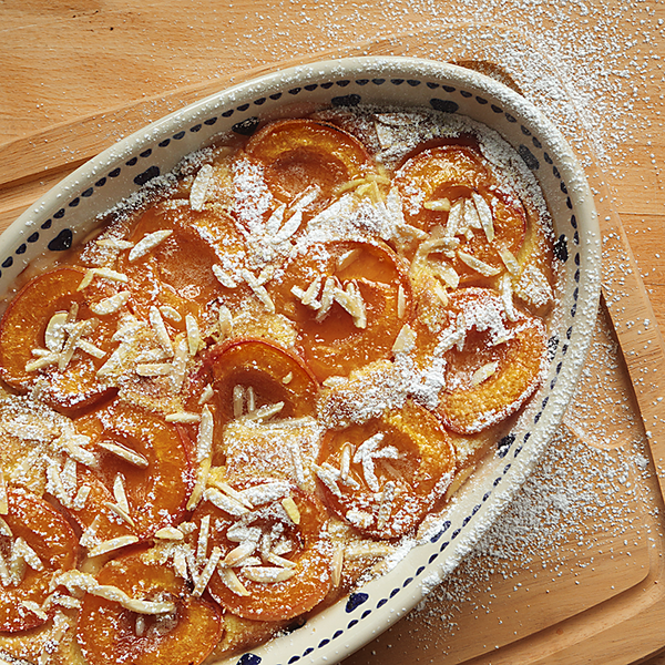 Aprikosen-Clafoutis mit Mandeln auf einen Holztisch