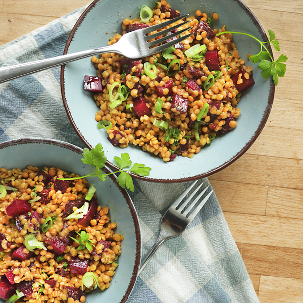 Rote Bete-Linsensalat in Schüsseln mit Gabeln auf einen Holztisch