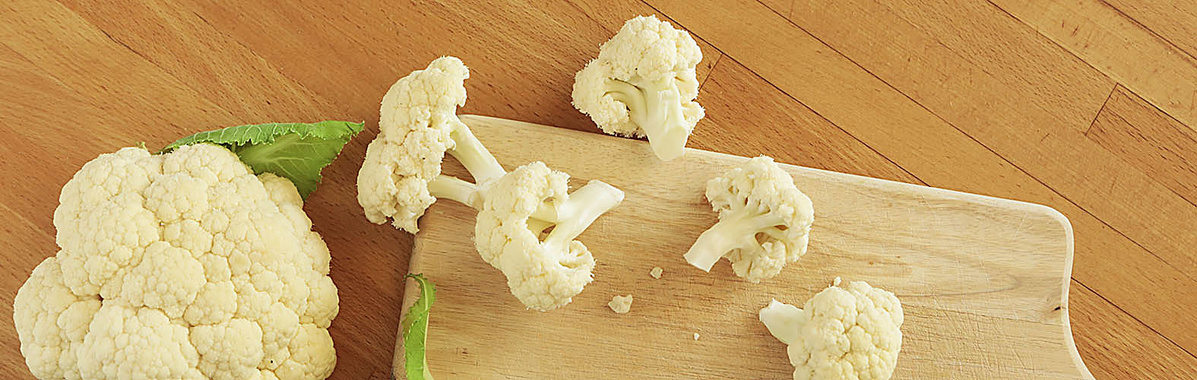 Blumenkohl und Blumemkohlröschen auf einem Holzbrett