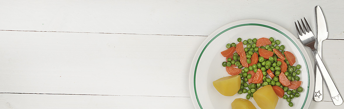Ein Gericht mit Kartoffel und Erbsen auf einen Kinderteller mit Besteck