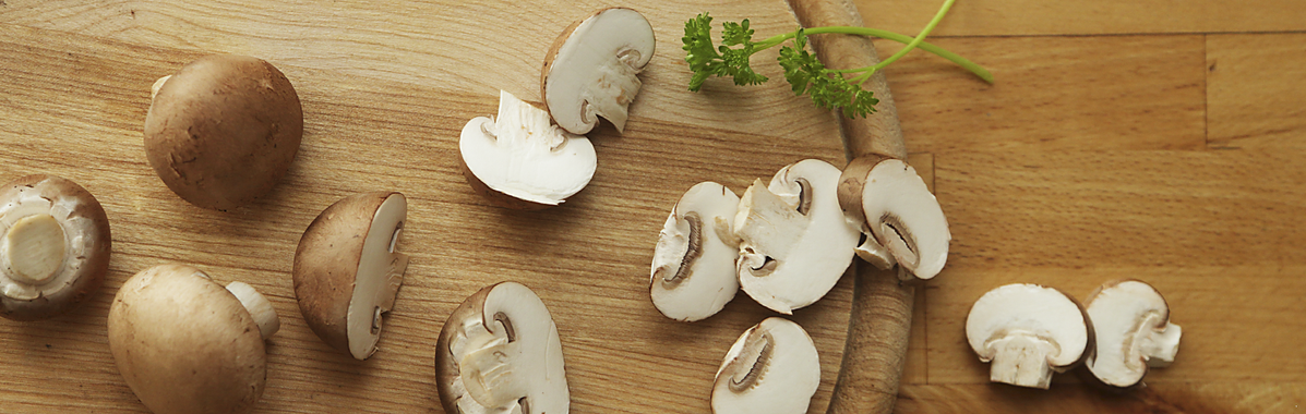 Champignons auf Holz mit Petersilie