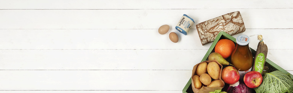 Gemüsekiste mit Eier und Milch auf weißem Holz