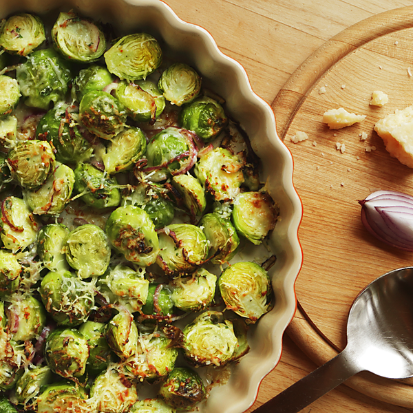 Apfel-Ziegenkäse-Flammkuchen mit einem Messer auf einem Holbrett