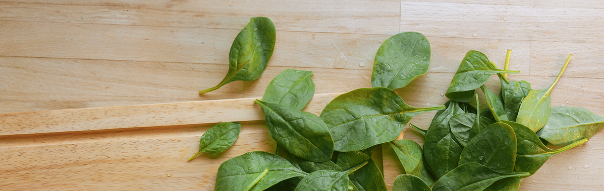 Frischer Spinat auf einen Holzbrett in Vorbereitung einer Spinat-Frittata
