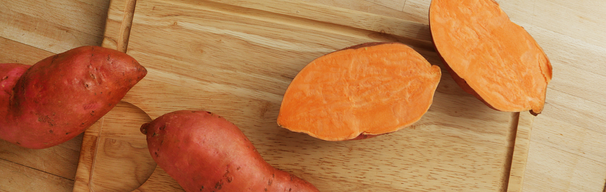 Süßkartoffel aufgeschnitten auf Holz