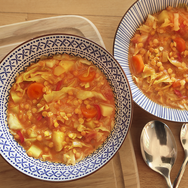 Spitzkohl-Curry in zwei Schüsseln auf einen Holztisch